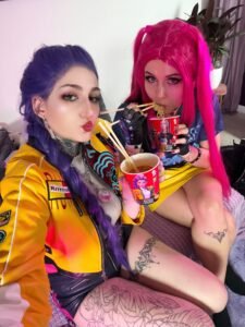 Two cosplayers with colorful hair drinking noodles from instant noodle cups in bright streetwear inspired cosplay